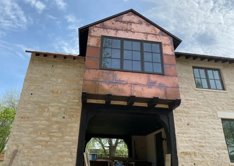 Copper metal panel facade on a stone building for Skylight Installation in Colton